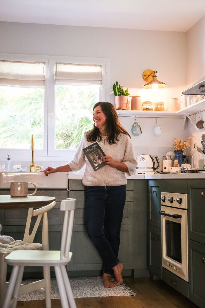 Marie Guédon, décoratrice d'intérieur, dans sa cuisine verte, blanche et bois au style classique intemporel